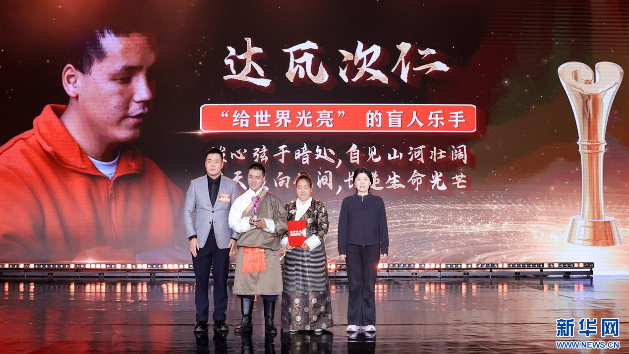 龍寧麗 、那志東為“給世界光亮”的盲人樂(lè)手達(dá)瓦次仁頒獎(jiǎng)（圖）