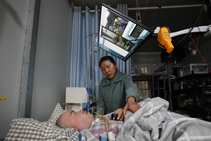 “重庆好人”黎夏用两根指头遥控农场的自动化系统。渝北区委宣传部供图